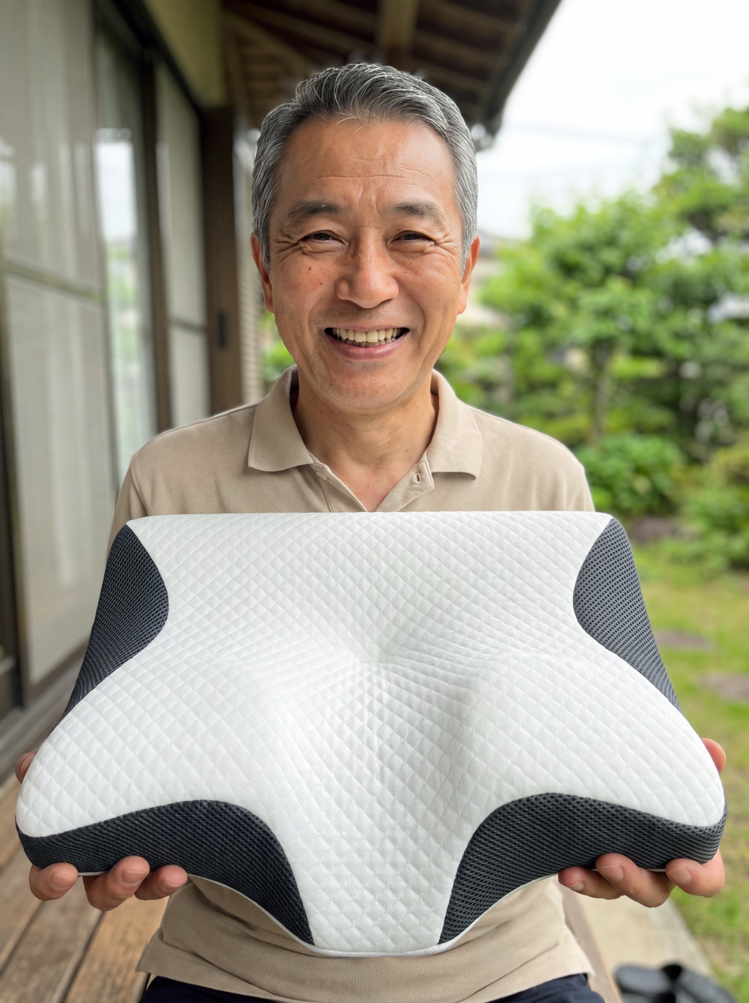 バルコニーでNEMURIEの枕を持つ男性